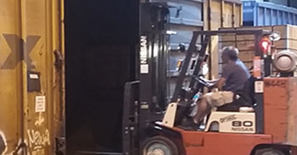 Carretilla elevadora operada por un hombre dentro de un almacén de logística de la cadena de suministro